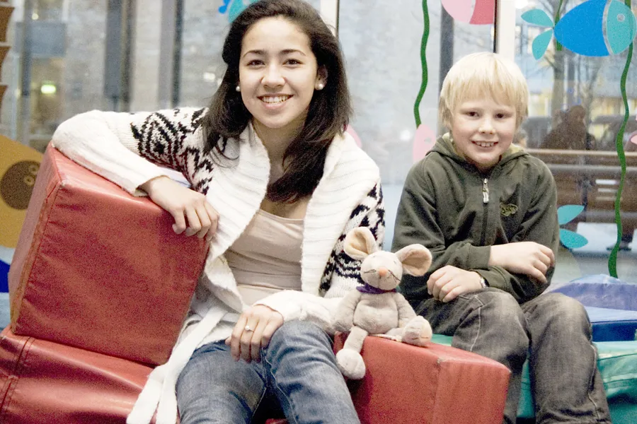 Tøymusen Rasmus sitter sammen med en gutt og en jente