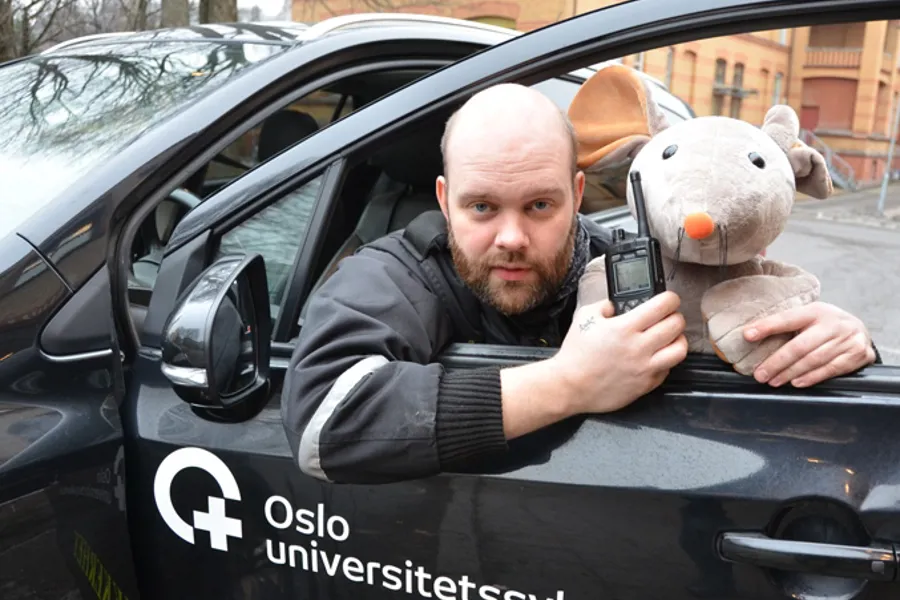 Tøymusen Rasmus sammen med ansatt i sikkerhetsseksjonen